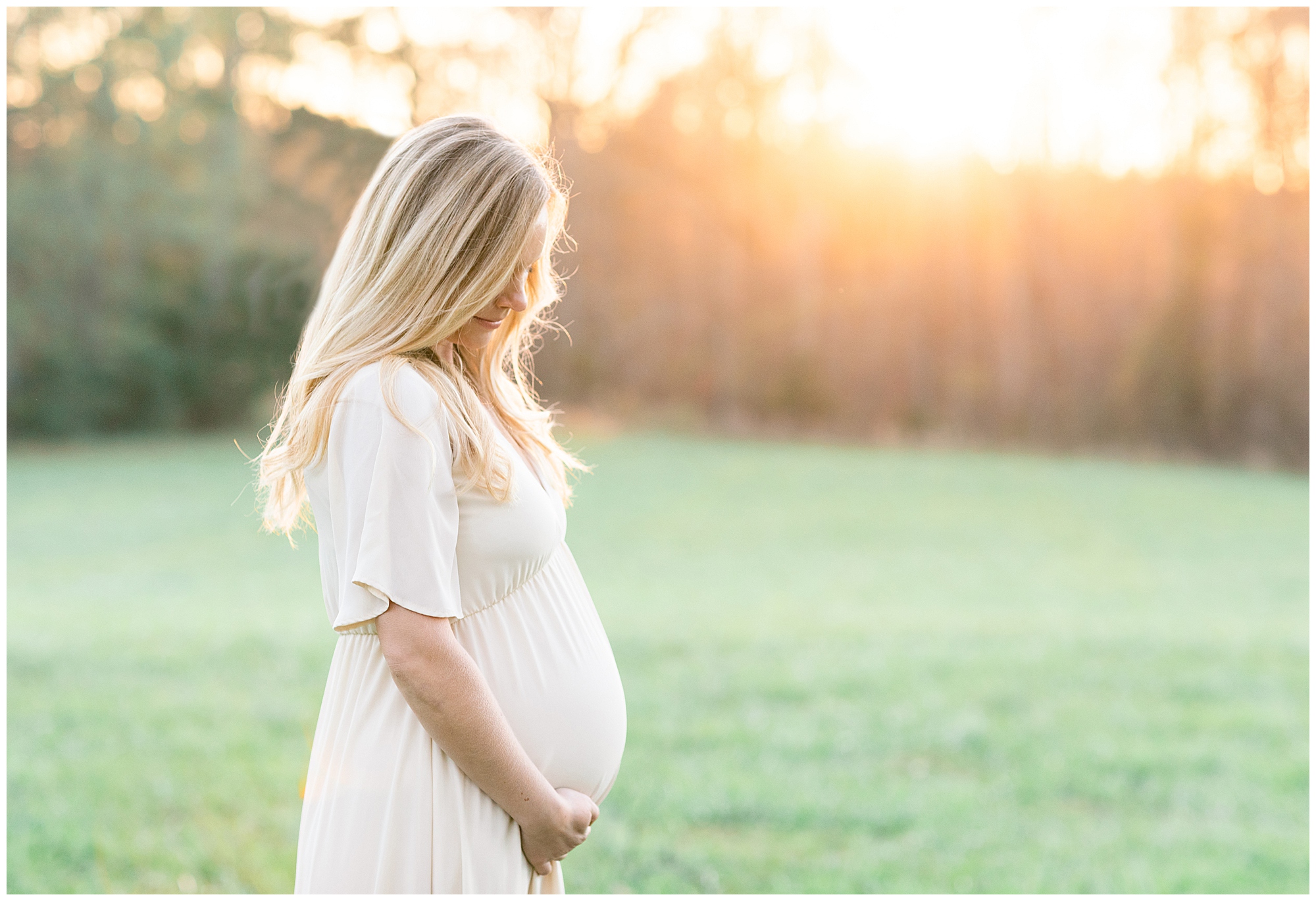 Mom to be in a field at sunset | Image by Chrissy Winchester Photography