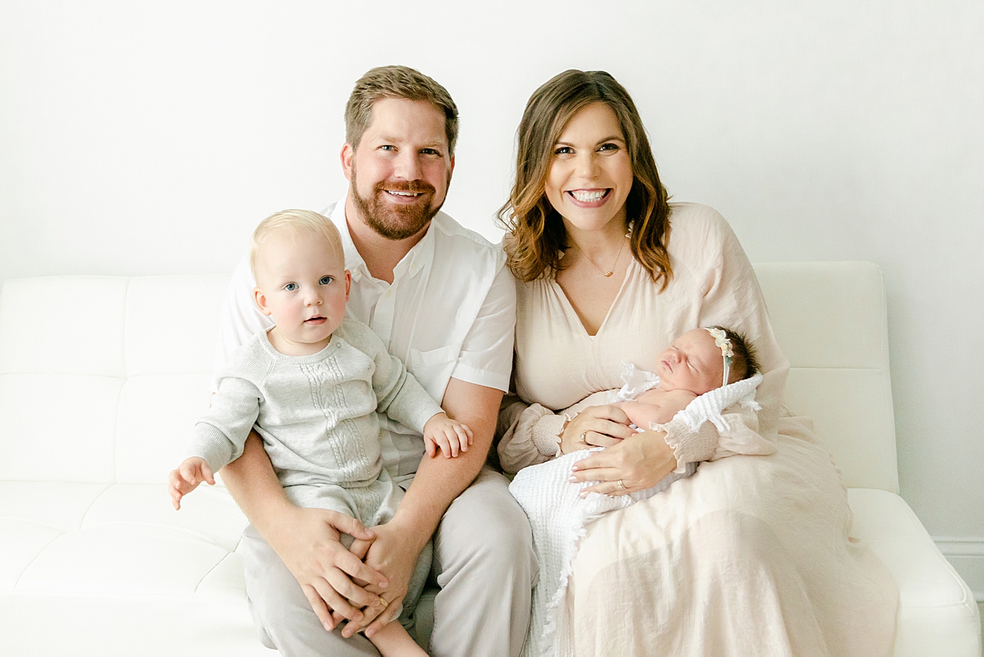 Mom and dad sitting with their little ones | Image by Chrissy Winchester