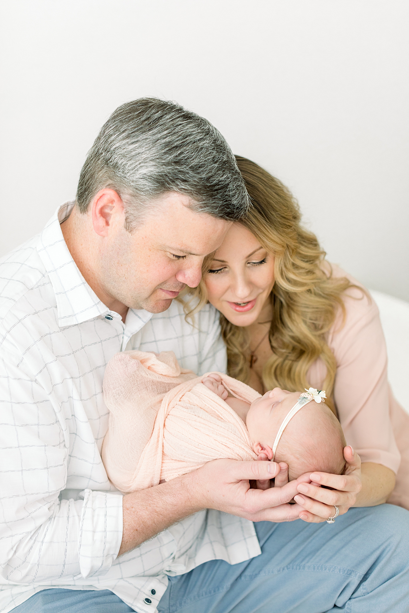 Mom and dad holding their baby girl | Image by Chrissy Winchester