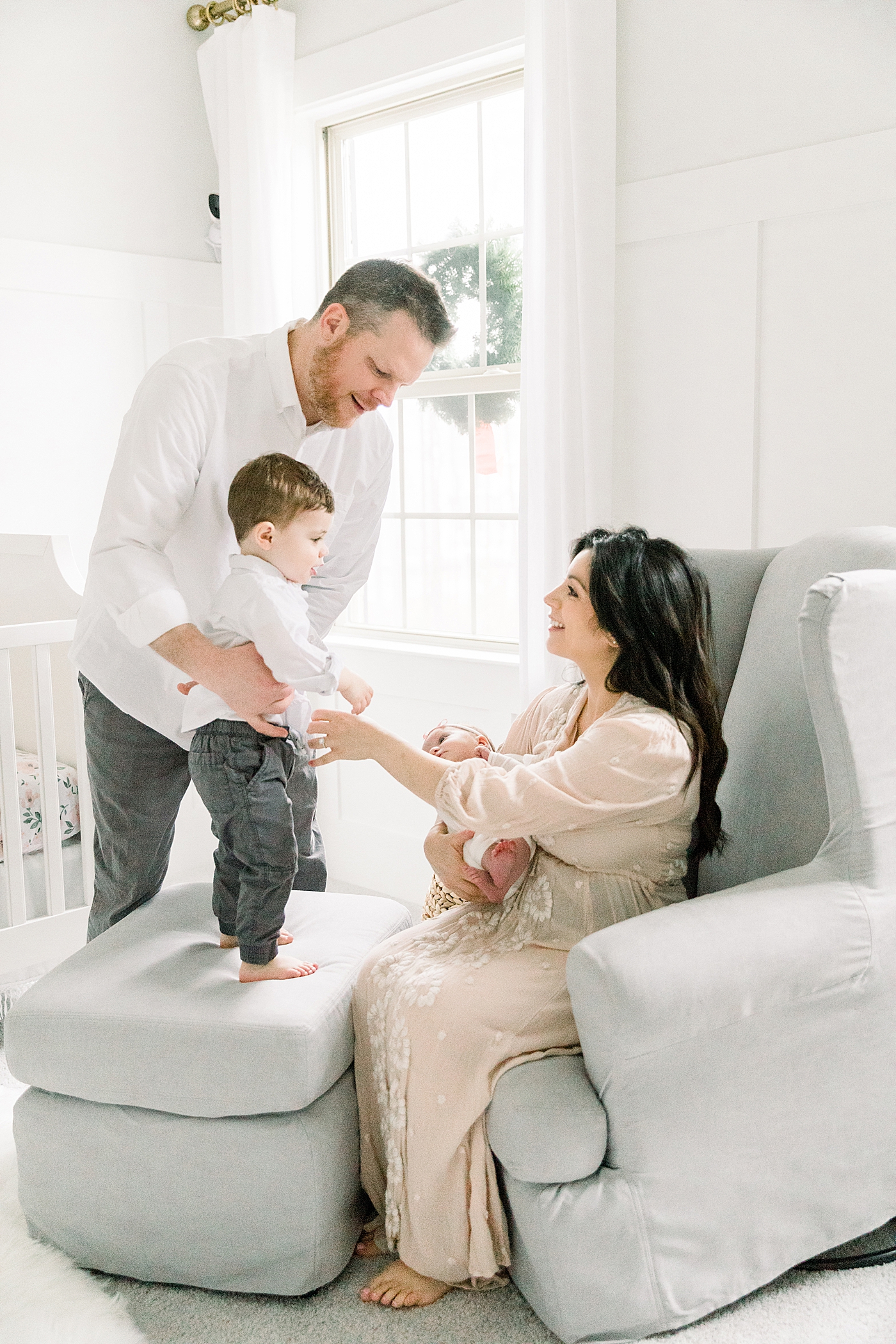 Family in a baby nursery during their newborn session | Image by Chrissy Winchester