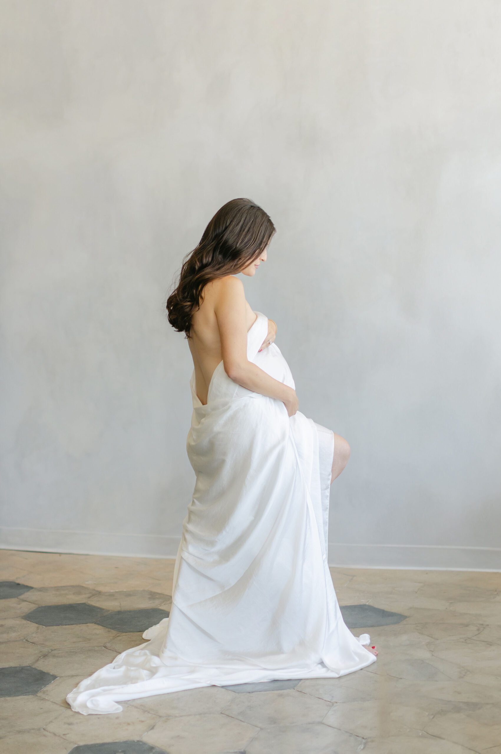 Expectant mom in artistic pose drapping fabric