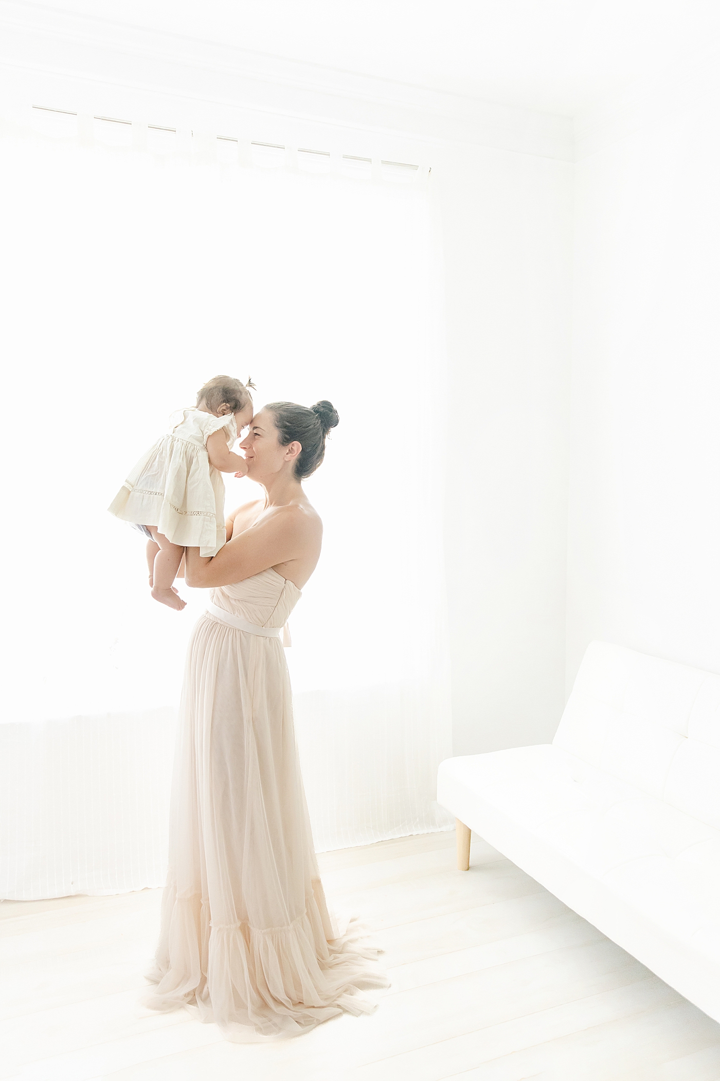 Mom holding her baby girl to her face during her Six Month Studio Session | Image by Chrissy Winchester Photography