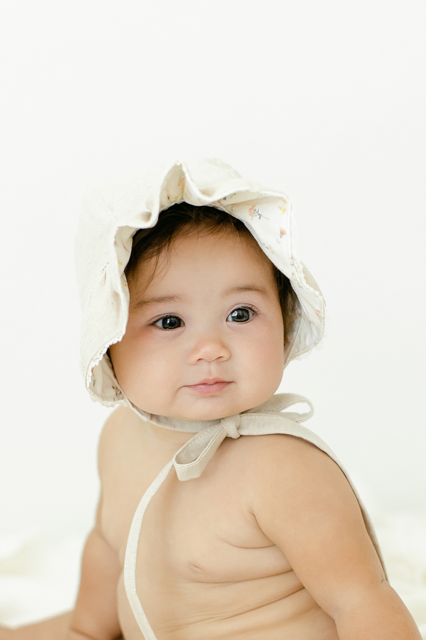 Detail of baby girl in a bonnet during her Six Month Studio Session | Image by Chrissy Winchester Photography