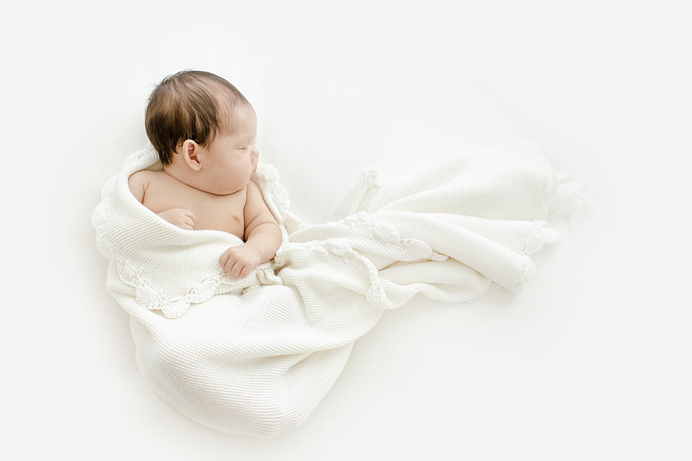 Baby girl wrapped in a white blanket | Image by Chrissy Winchester